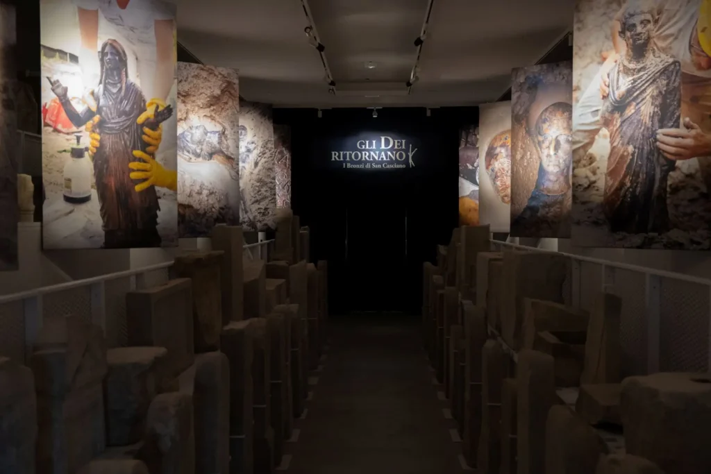 Sala introduttiva del percorso espositivo con immagini a colori che ritraggono momenti dello scavo archeologico del santuario di San Casciano ai Bagni.